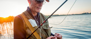 釣り針に餌を付ける年配の男性