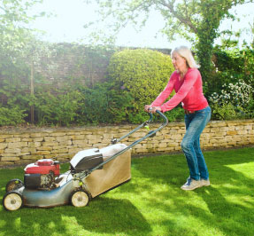 A woman pushing a lawn mower