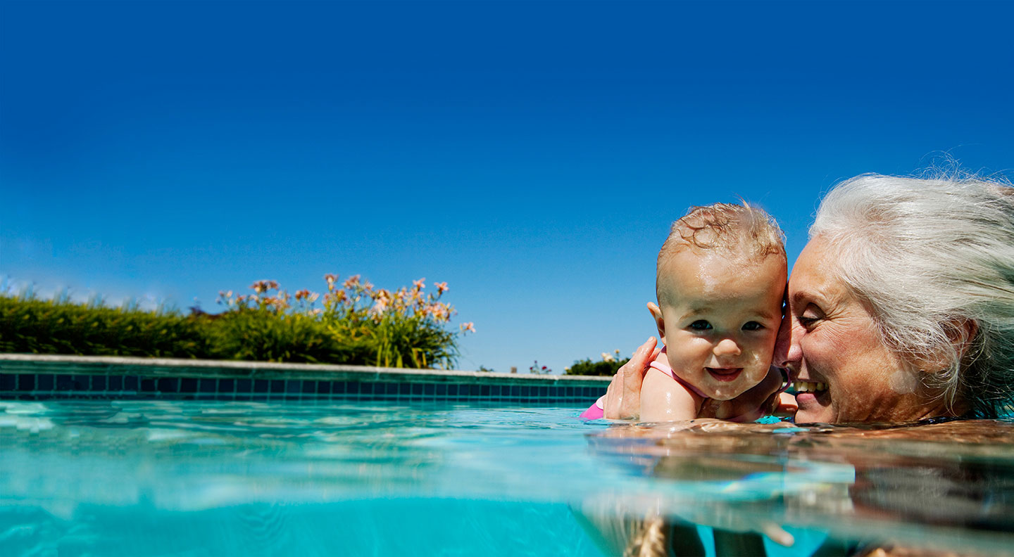 senior and baby smiling in pool